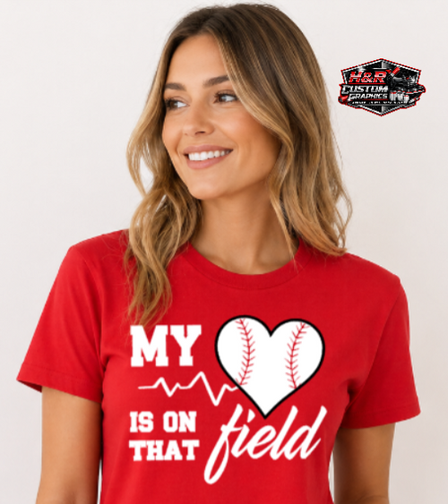 Woman wearing red baseball mom shirt that says "My Heart Is On That Field" with baseball heart graphic