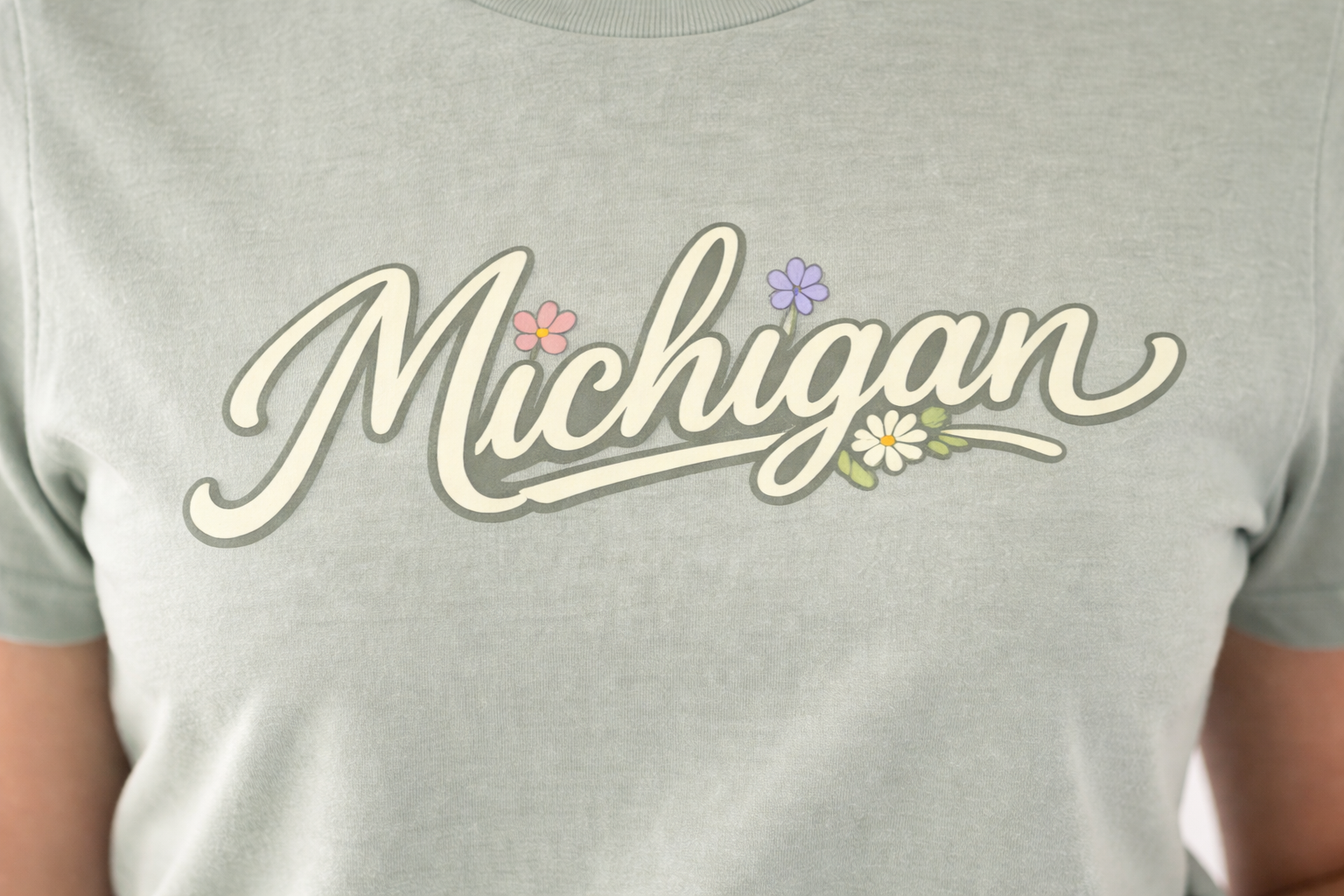 Gray t-shirt with 'Michigan' text and floral decorations on a person wearing it.